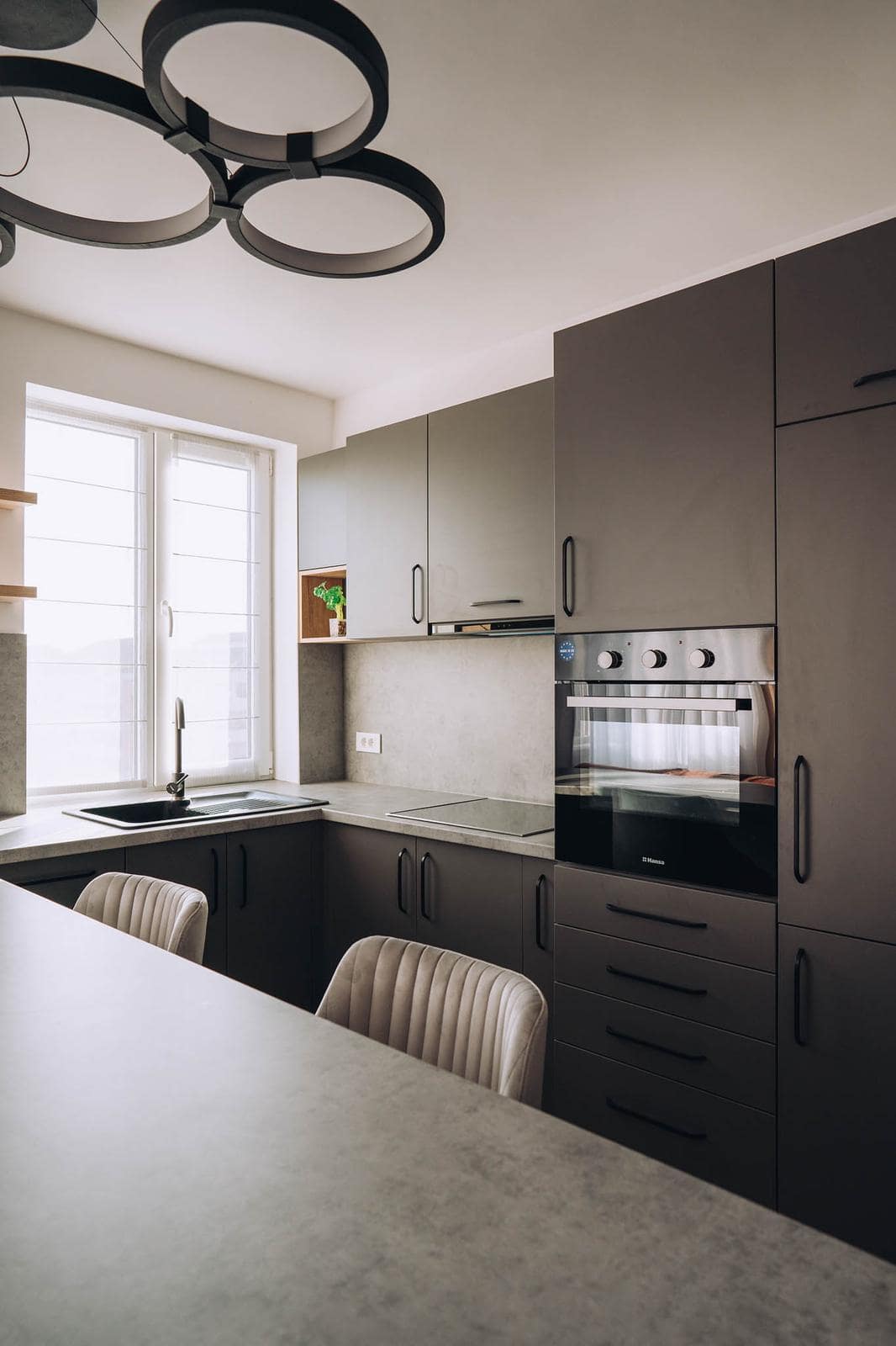 Black metal ring light fitting above the graphite kitchen counter